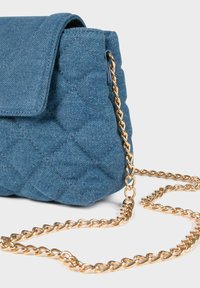 Borsa a tracolla in denim con design trapuntato, colore blu, chiusura a flap magnetico e tracolla in catena dorata. Il tessuto testurizzato arricchisce l'interesse visivo.