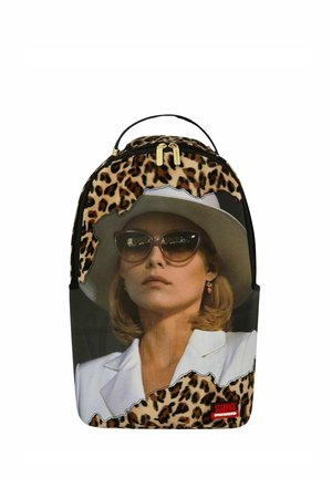 Mochila con estampado de leopardo y una gran foto de una mujer que lleva gafas de sol, un sombrero blanco y un blazer blanco.