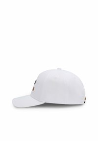 Weißes Basecap mit gebogenem Schirm, ausgestattet mit schwarzen Augen und einem braunen Fleckdesign. Hergestellt aus Stoff mit einer strukturierten Form und verstellbarem Riemen.