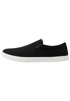 Black slip-on canvas sneaker with white rubber sole, elastic side panels, and low-profile design.