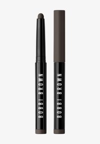 Musta sylinterimäinen meikkikynä matskamaalilla; korkin pää on tummaa ruskeaa. Vahva valkoinen "BOBBI BROWN" -brändäys.