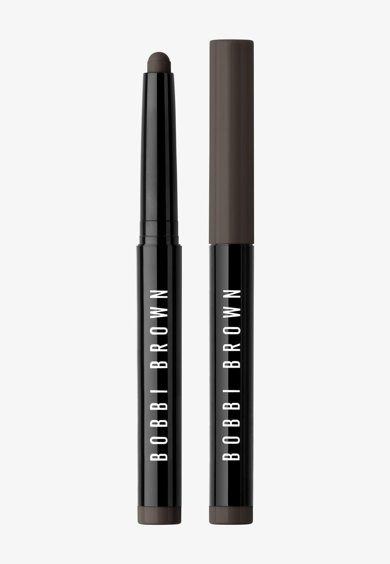 Musta sylinterimäinen meikkikynä matskamaalilla; korkin pää on tummaa ruskeaa. Vahva valkoinen "BOBBI BROWN" -brändäys.