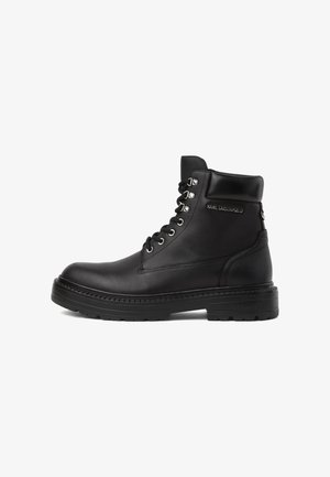 Bottine noire en cuir avec laçage à l'avant, col rembourré, semelle épaisse crantée et logo "KARL LAGERFELD" sur le côté.