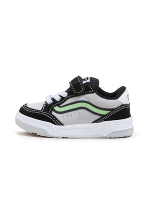 Czarny i szary dziecięcy sneaker z białymi sznurówkami, zielonym paskiem z boku, rzepem i białą gumową podeszwą na białym tle.