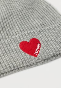 Γκρι ριγωτό σκουφάκι με κόκκινο μπαλώμα σε σχήμα καρδιάς που έχει κεντημένη τη λέξη «FUTURE» με λευκά γράμματα. Μαλακή υφή, ελαστική εφαρμογή.