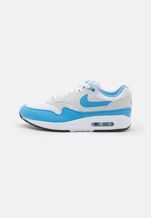 Witte en blauwe Nike Air Max sneaker van opzij gezien, met zichtbare luchtvering en vetersluiting.