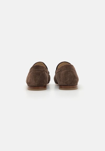 Mocassins en daim marron avec un profil bas, un bout arrondi et des détails de coutures minimalistes. Semelles en bois avec une finition lisse.