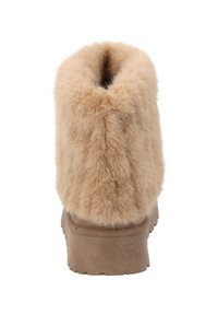 Beige Winterstiefel mit dickem Gummisohle und flauschigem, beigem Fell, vom Rücken gezeigt.