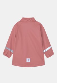 Roze waterdichte jas met een kraag, elastische mouwen en reflecterende zilveren strepen. Bevat een vierkant label met een witte "R" aan de zoom.