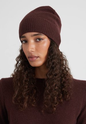 Burgundy ribbed knit beanie with a fitted design, made of soft fabric. Features a textured surface and a smooth finish.
