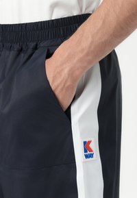 Marineshorts med elastisk talje, hvide sidelæg og et logo-patch. Letvægts, vandafvisende materiale; har sidelommer.