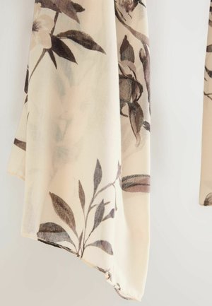 Plāns šalle krēmkrāsā ar ziedu rakstu brūnos toņos. Viegls audums, maiga tekstūra un nedaudz plēsta mala.