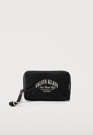 Zwart rechthoekig Calvin Klein etui met witte logotekst en een zwart-witte stoffen polsband aan de linkerkant.