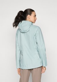Ljust blått vattentätt jacka med huva, med en avslappnad passform, långa ärmar och en mjuk textur, designad för utomhusbruk.