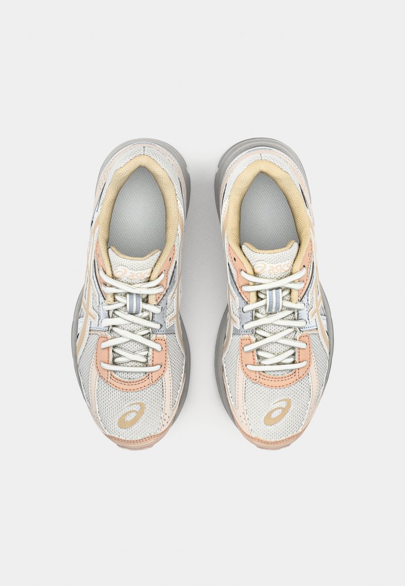 Scarpe sportive grigie e argento con accenti beige, parte superiore in rete, punta tonda e chiusura con lacci. Presentano il logo sui lati e colletto imbottito.