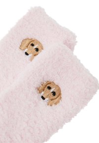Calzini rosa soffici con una faccia di cane ricamata in beige e marrone. Texture morbida con forma arrotondata e dettagli delicati.