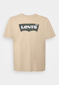 T-shirt en coton beige avec un logo Levi's vert foncé et blanc. Encolure ronde classique, manches courtes et design à ourlet droit.