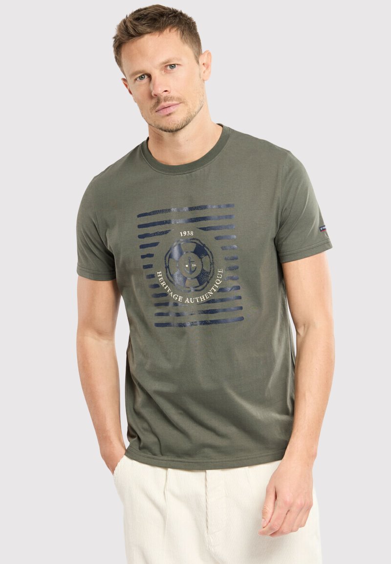 T-shirt en coton vert olive avec un logo circulaire imprimé bleu marine et des rayures horizontales. Col rond et manches courtes, texture douce.