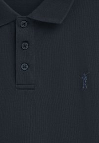 Polo de color navy hecho de algodón texturizado con cuello tipo polo, que presenta tres botones a juego y un logo bordado de un golfista en azul.