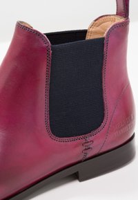 Bordó kožené Chelsea boty s černou elastickou boční panely, hnědým koženým interiérem a černou podrážkou, s vyraženým logem na patě.