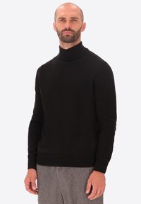 Maglione a collo alto nero realizzato in pregiato tessuto a maglia. Presenta un design aderente con maniche lunghe e polsini e orlo a coste.