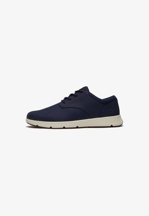 Navyblauwe casual herensneaker met witte rubberen zool, vetersluiting en subtiel merkembleem op de hiel.