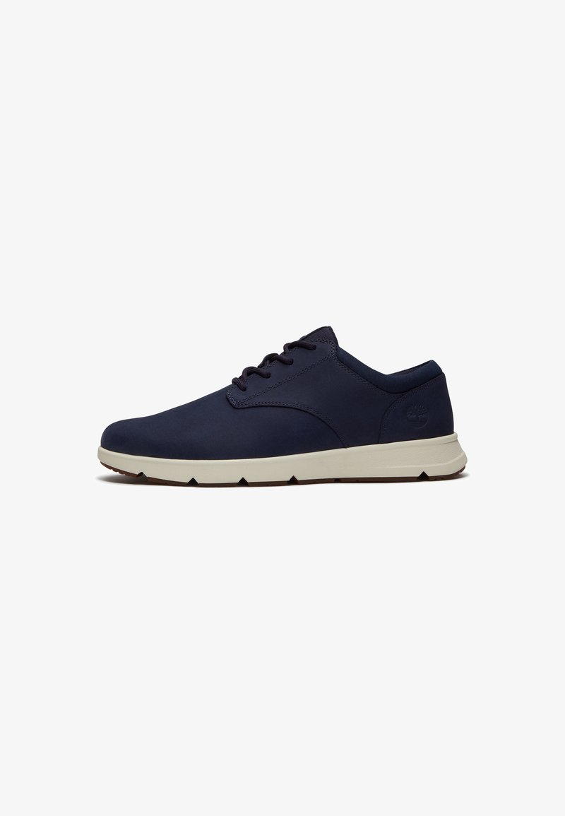 Zapatilla deportiva casual para hombre en azul marino con suela de goma blanca, cierre de cordones al frente y logotipo sutil de la marca en el talón.