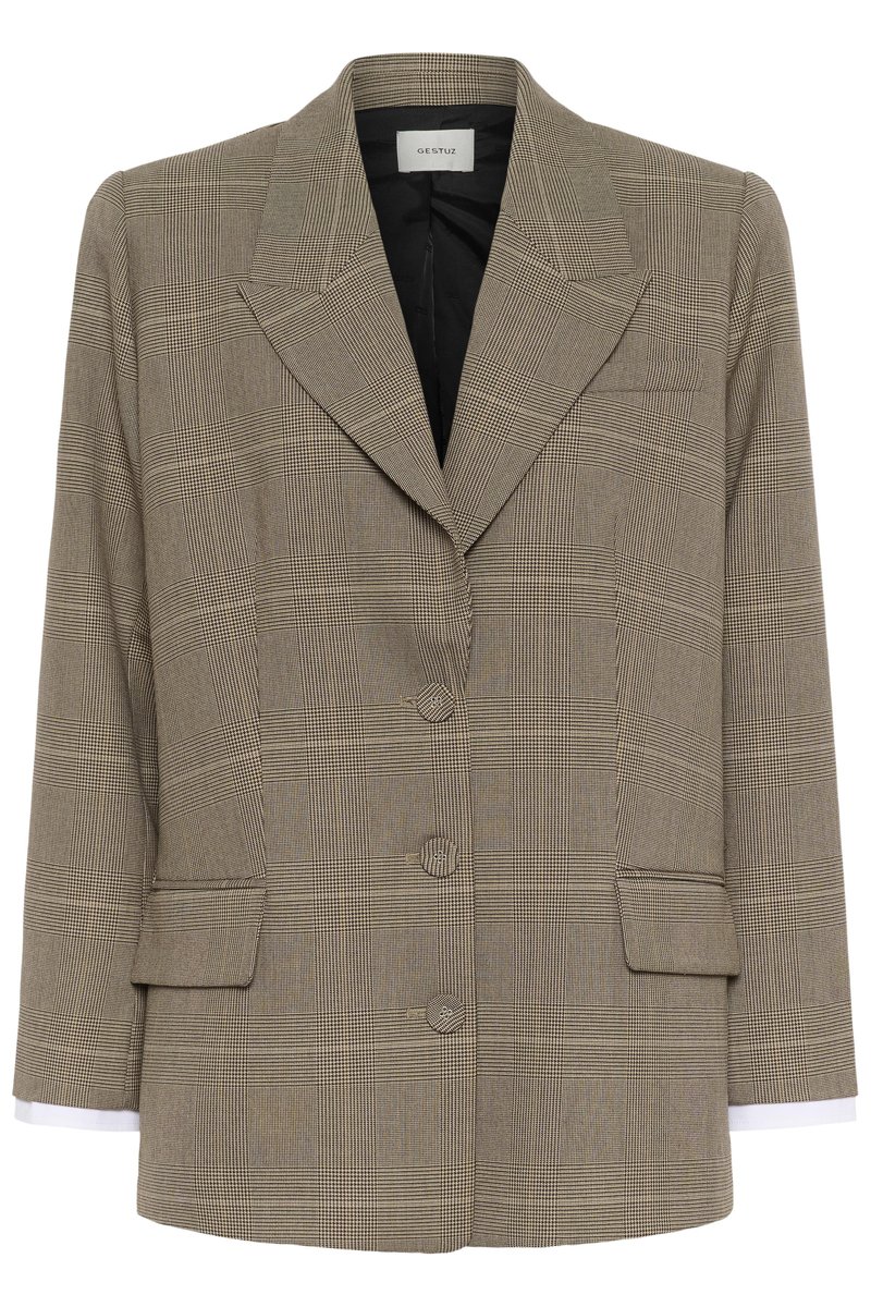 Blazer à carreaux marron et noir avec larges revers, trois boutons sur le devant, poches à rabat, et manches longues avec poignets de chemise blanche visibles.