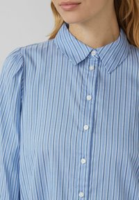 Blauw gestreepte shirt met een kraaghals, voorzien van witte verticale strepen, knoopsluiting aan de voorkant en een gestructureerde stof.