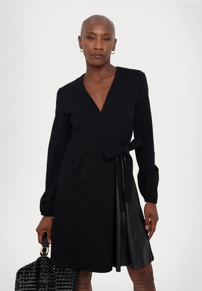 Schwarzes Wickelkleid mit langen Ärmeln, einem Bindegürtel in der Taille und einem mit Leder akzentuierten Saum. Hergestellt aus einem glatten Stoff mit minimalen Details.