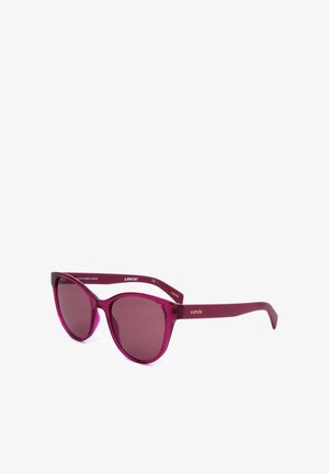 Occhiali da sole viola traslucidi con forma a occhio di gatto, lenti sfumate e logo Levi’s dorato sulle aste, esposti su sfondo bianco.