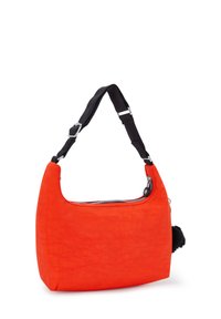 Orange tygaxelväska med rundad topp, svart justerbar rem, silverdragkedja och en texturerad svart pom-pom-detajl på sidan.