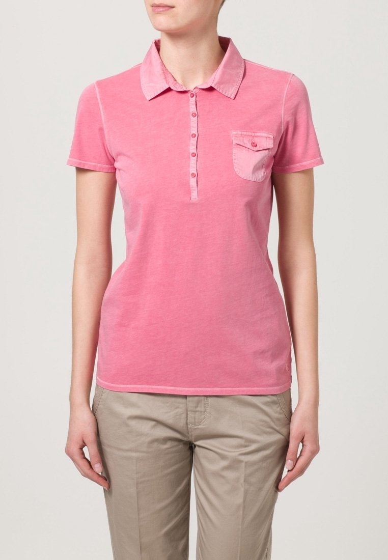 Polo shirt in cotone rosa con colletto, maniche corte, patta con bottoni e una piccola tasca sul petto. Texture morbida e design casual.