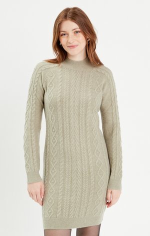Robe pull en vert clair avec des motifs en câble texturés, col montant et manches longues. Matériau doux, silhouette ajustée, bords et ourlet côtelés.