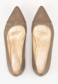 Ballerines en cuir beige à bout pointu, texture lisse et semelle intérieure dorée avec le nom de la marque en relief.