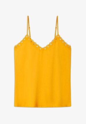 Camisole jaune avec bretelles spaghetti ajustables, dotée d'un bord festonné orné de découpes circulaires et d'une texture lisse.
