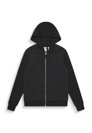 Sudadera negra con cremallera, con un frente texturizado, mangas lisas, capucha ajustable con cordones y puños de canalé. Presenta dos bolsillos frontales y una cremallera plateada.