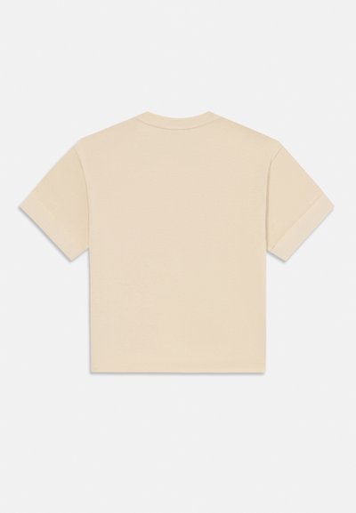 Beige színű, rövid ujjú, cropped póló, felhajtott mandzsetta látható hátulról, egy sima fehér háttéren.