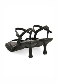 Sandalias negras de tacón con correas trenzadas, diseño de punta abierta y acabado brillante. El tacón mide aproximadamente 6 cm de altura y tiene forma cuadrada.