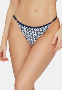 Mutandine bikini a motivi blu navy e bianche con vita bassa, caratterizzate da dettagli in metallo ai lati e un tessuto morbido per il massimo comfort.