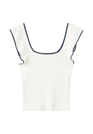 Junge Frau trägt ein weißes ärmelloses Oberteil mit quadratischem Ausschnitt, blaue Jeansshorts mit seitlicher Schnürung und schwarze Riemchensandalen, steht vor einfarbigem Hintergrund.