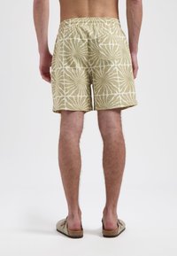 Linnen zwembaden met een elastische tailleband, voorzien van een beige en witte bloemenpatroon. Achterzak aan de rechterkant, vlakke zoom.