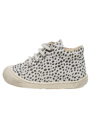 Sneaker bianco con pois neri, tomaia in tessuto, punta rotonda e suola piatta in gomma. Presenta lacci grigi e rivestimento interno marrone chiaro.