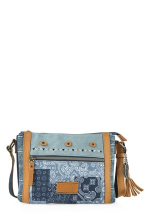 Bolso cruzado con un diseño de patchwork en tonos azules, que presenta tela vaquera y tejido estampado, acentos de cuero marrón y un borlón decorativo.