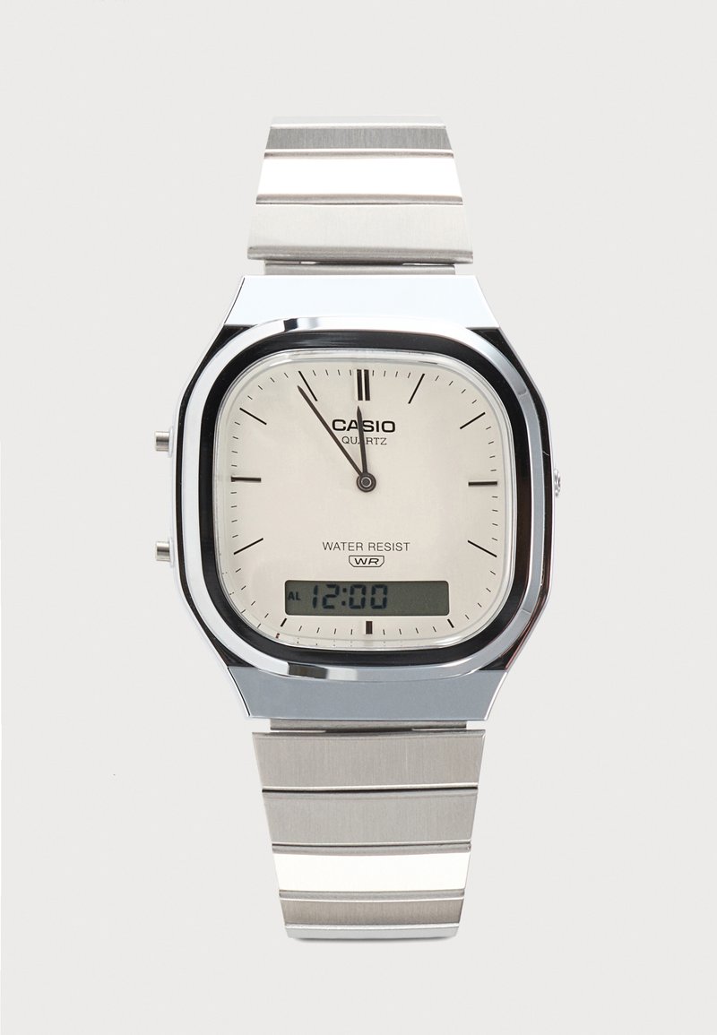 Montre-bracelet Casio argentée avec affichages analogique et numérique, affichant 12h00, étiquetée quartz et résistante à l'eau avec un bracelet en métal à maillons.