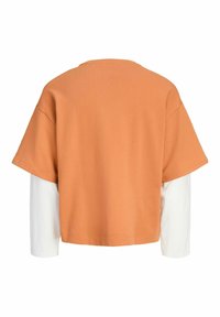 Vue de dos d'une chemise à couches avec un haut orange large à manches courtes sur des manches longues blanches sur un fond uni.