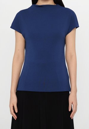 Haut bleu marine à manches courtes avec un col rond. Confectionné dans un tissu lisse et extensible, il présente une coupe ajustée sans motifs ni accents visibles.