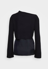 Czarny, długi rękaw, krótki dzianinowy top nałożony na jedwabistą, czarną, bezrękawnikową bluzkę, pokazany od tyłu na jednolitym białym tle.