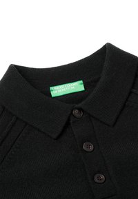 Czarna, dzianinowa koszulka polo o teksturowanym wykończeniu, z kołnierzykiem, trzema ciemnymi guzikami i zieloną etykietą z napisem "United Colors of Benetton."