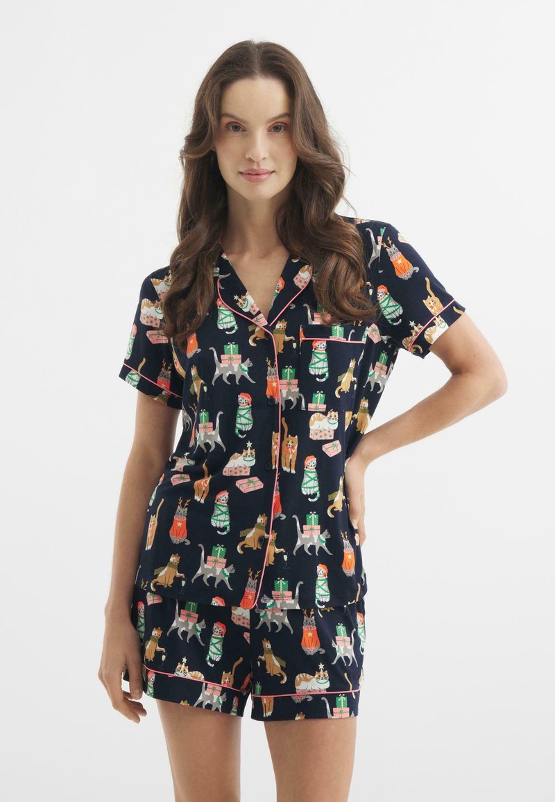 Niebieski zestaw piżamowy z krótkim rękawem i szortami, ozdobiony kolorowymi nadrukami zwierząt i wzorami prezentów, wykończony jasnoróżowym kolorem.